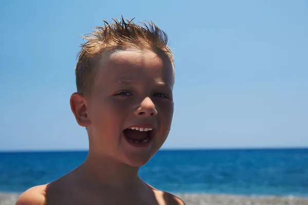 Niño divertido en la playa.niño sonriente cerca del mar —  Fotos de Stock