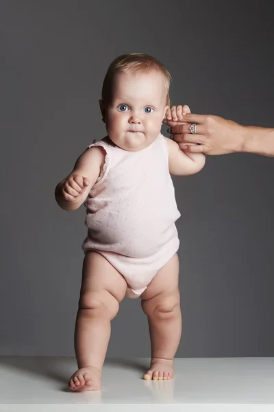 Πρώτο βήμα baby.adorable κοριτσάκι. αστείο, το παιδί προσκολλάται στα χέρι της μητέρας της — Φωτογραφία Αρχείου