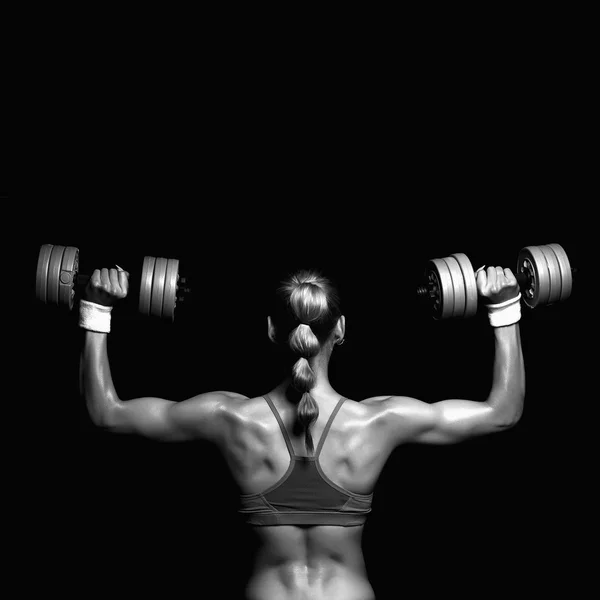 Monochromatické portrét mladé ženy kulturista s dumbbells.blonde dívkou s svaly — Stock fotografie