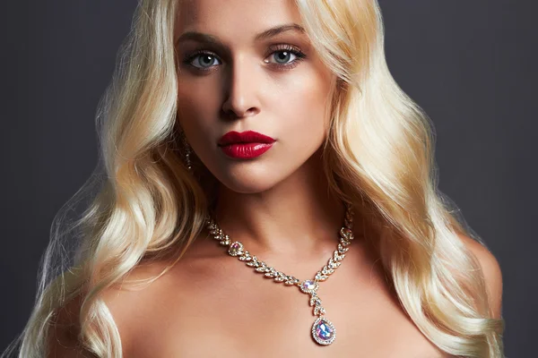 Luxe mooie jonge vrouw met gezonde curl blond haar. lang golvend haar meisje met make-up en sieraden. Sexy Model — Stockfoto