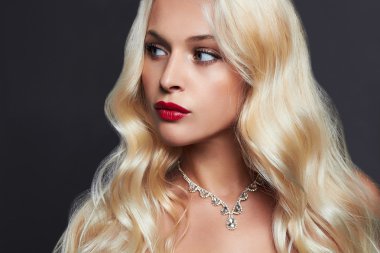 lüks sağlıklı curl sarışın saçlı güzel genç kadın. uzun dalgalı saçlı kız makyaj ve takı. Seksi Model
