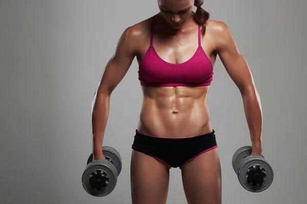 Mulher fisiculturista fitness com dumbbells.beautiful menina loira com músculos — Fotografia de Stock