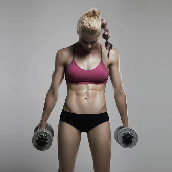Γυναίκα bodybuilder καταλληλότητας με dumbbells.beautiful ξανθιά κοπέλα με τους μύες — Φωτογραφία Αρχείου