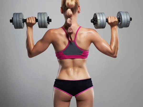 Γυναίκα bodybuilder καταλληλότητας με dumbbells.blonde κορίτσι με τους μύες — Φωτογραφία Αρχείου