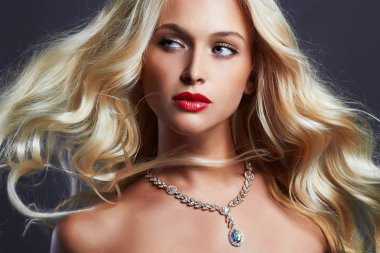 kıvırcık saç ve takı güzel genç kadın. Kırmızı dudaklar ve mavi gözlü sarışın kız