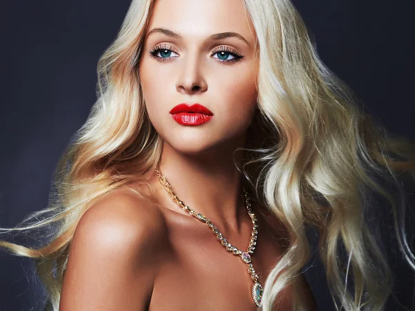 Krásná mladá žena s kudrnatý účes a šperky. Blonďatá dívka s červenými rty a modré oči — Stock fotografie