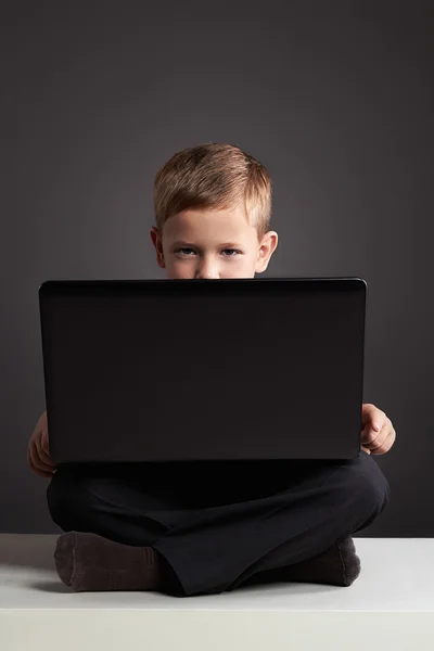 Fiatal fiú számítógéppel. vicces gyerek keresi a notebook. oktatás — Stock Fotó