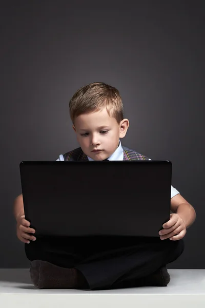 Young boy with computer. funny child looking in notebook. education — Stock Photo, Image