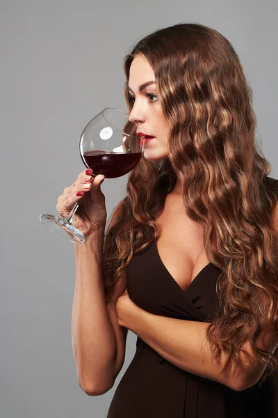 Giovane splendida ragazza bruna con bicchiere di vino rosso.Bella donna bionda che beve vino rosso — Foto Stock