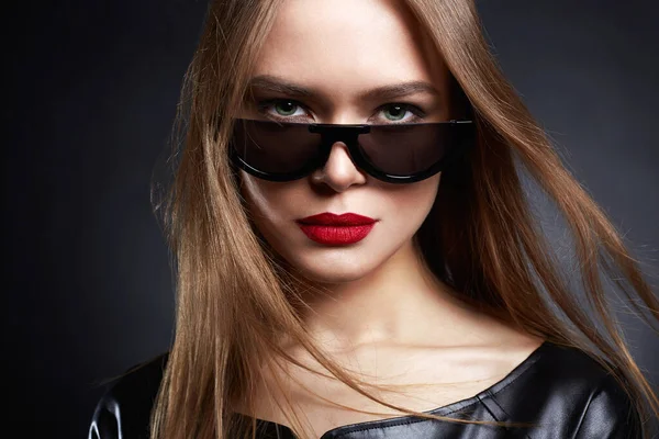 Güneş Gözlüklü Sağlıklı Saçlı Güzel Bir Genç Kadın Deri Elbiseli — Stok fotoğraf