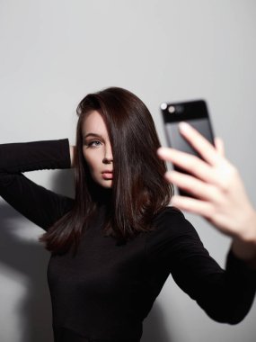 Sosyal ağ için selfie çeken güzel genç bir kadın.