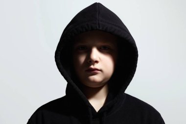 Siyah kapüşonlu küçük çocuk. Genç çocuğun yakın plan portresi. Çocuk