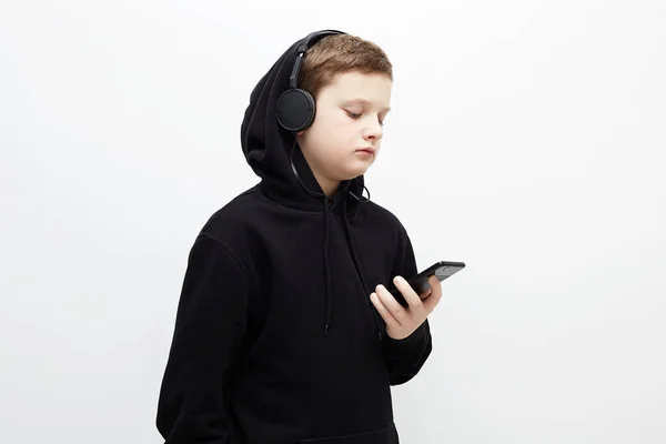 Fekete Csuklyás Kisfiú Fülhallgató Stílusos Tinédzser Fiú Zenét Hallgat Telefonon — Stock Fotó