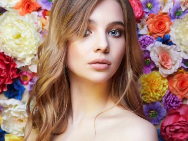 Çiçekli güzel bir kadın. rengarenk çiçekli arka planda. Güzel sarışın kız.