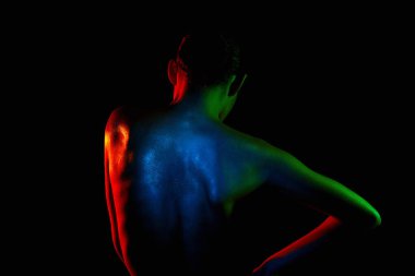 Renkli parlak ışıklardaki kadın. Güzel çıplak kız silueti