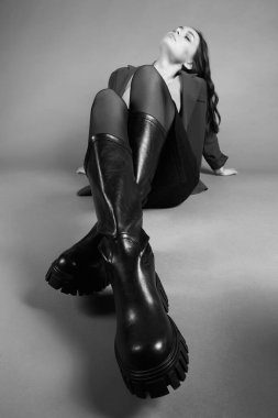 Yüksek çizmeli kadın bacakları. Şık deri ayakkabılar giyen güzel genç bir kadın.