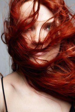 Kıvırcık kızıl saçlı ve makyajlı güzel bir kadın. Sağlıklı saçlı kızın güzel portresi.