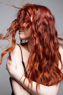 Güzel, mutlu, uzun kızıl saçlı bir kadın. Sağlıklı saçların güzel portresi gülümseyen kız