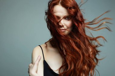 Uçan kızıl saçlı güzel bir genç kadın. Sağlıklı saçlı kızın güzel portresi.