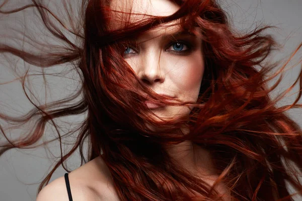 beautiful young woman with flying red hair. beauty portrait of healthy hair girl