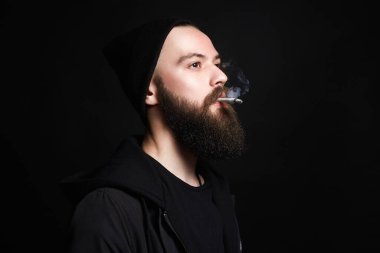 Şapkalı yakışıklı, sakallı, sigara içen adam. Sigaralı hippi çocuk.