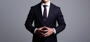 Resmi stil adamı. Buisnessman. Takım elbiseli ve kravatlı patron ellerini kilitte tutuyor. Liderlik