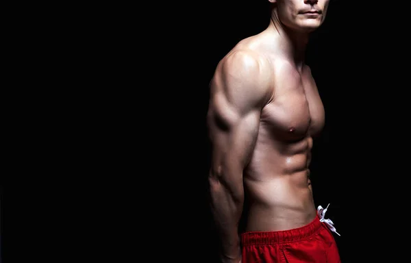 赤のショートパンツのトップレスセクシー男 ボディビルダー 裸の体の筋肉少年 体育館 — ストック写真