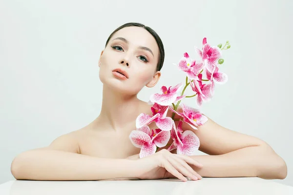 花を持つ美しい若い女性 蘭の花の女の子の美しさの肖像 — ストック写真