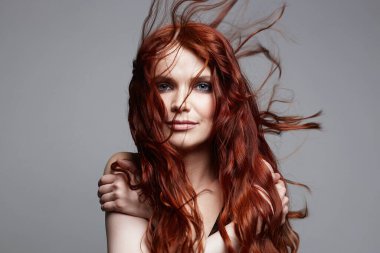 Kıvırcık kızıl saçlı güzel bir genç kadın. Sağlıklı saçlı kızın güzel portresi.