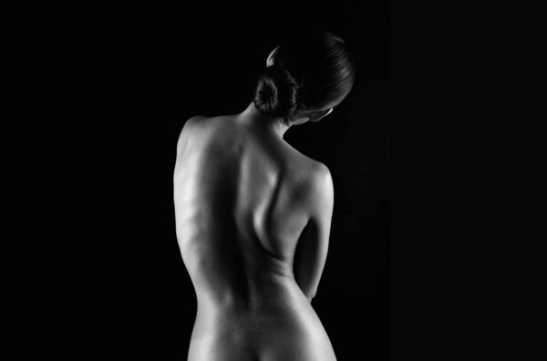 Female Nude silhouette of spine. Naked Woman. Sensual Girl in dark. Beautiful Back