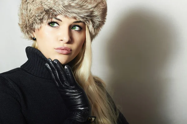 Mooie jonge vrouw in bont hoed. vrij blond meisje. winter mode beauty.beautiful blond meisje in zwart lederen handschoenen — Stockfoto