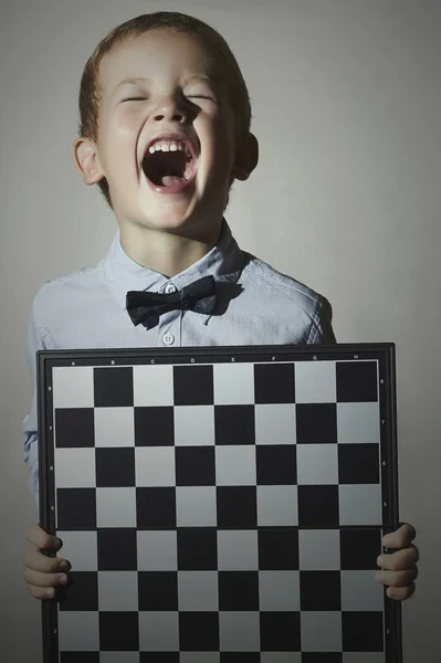 Grappige kleine jongen met chessboard.children emotion.smile.laughter — Stockfoto