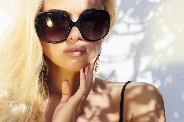 Beautiful woman in sunglasses.beauty blond girl in near the wall. Summer — Stock Photo, Image