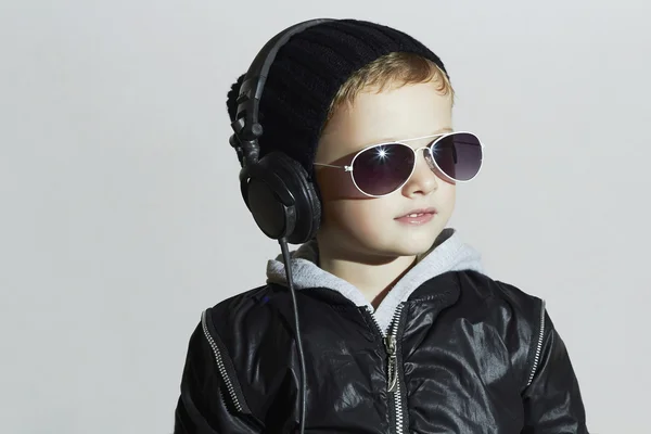 Lille djævel. sjov dreng i solbriller og headphones.child lytter musik. dj - Stock-foto