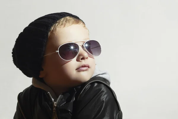 Ragazzino alla moda con gli occhiali da sole. Bambino in berretto nero. Inverno style.Kids moda — Foto Stock