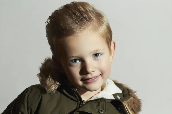 Lustiges modisches Kind im Wintermantel. fashion kids.children.khaki parka.smiling little boy. Frisur — Stockfoto