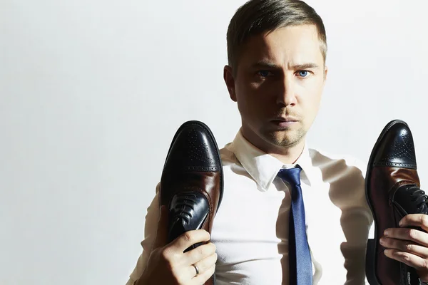 Mode portret van knappe man houdt schoenen. Zakenman in gelijkspel — Stockfoto