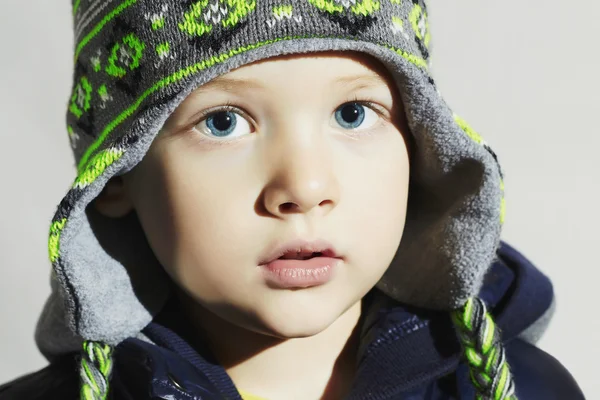 Niño con ojos azules.fashion kids.fashionable niño pequeño en gorra de invierno —  Fotos de Stock