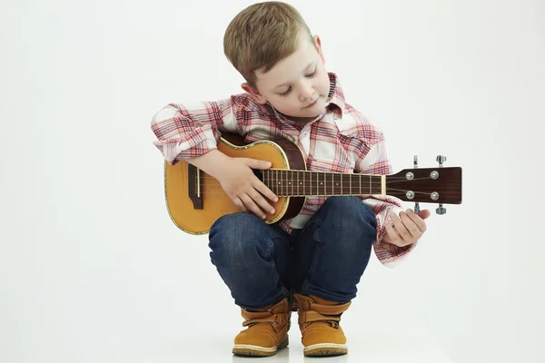 Niño divertido con guitarra. chico country de moda tocando música —  Fotos de Stock