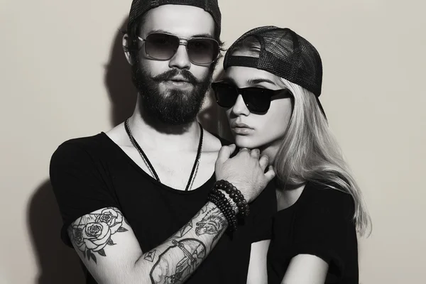 Hermosa pareja juntos. Tatuaje Hipster chico y chica. Joven barbudo y rubia en gafas de sol — Foto de Stock