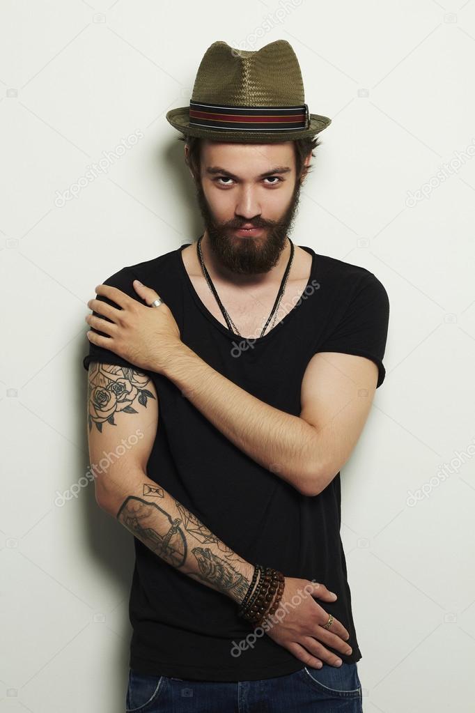 handsome man in hat.Brutal bearded boy with tattoo