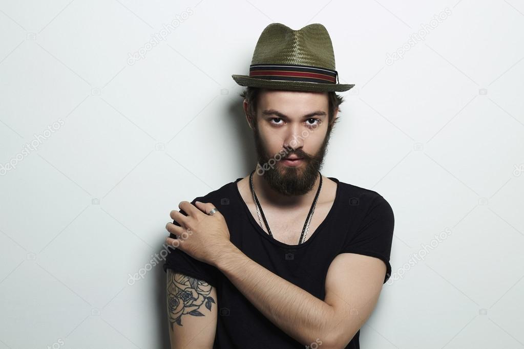 handsome man in hat.Brutal bearded boy with tattoo