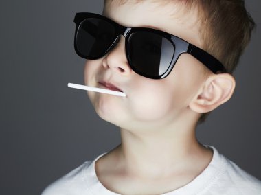 A Lollipop.Fashionable çocuk güneş gözlüğü ile komik genç çocuk