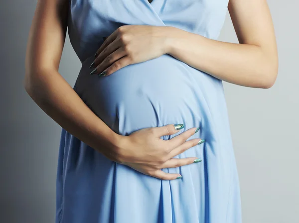 Pregnant woman touching her belly with hands Royalty Free Stock Images