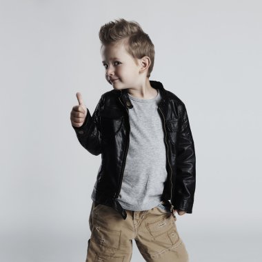 Fashionable child in leather coat.little boy hairstyle. Autumn funny smiling kid