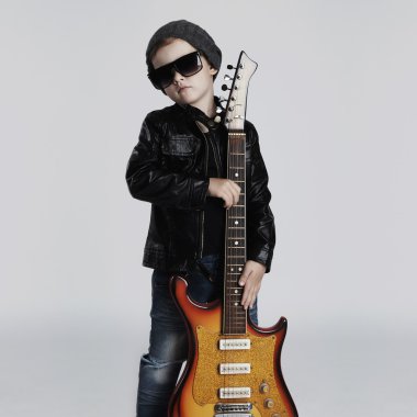 Funny rock child with guitar.fashionable little boy in sunglasses
