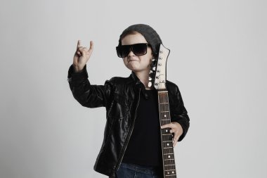 Funny rock child with guitar.little boy in sunglasses