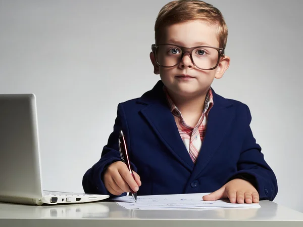 Ung affärsman använder en bärbar dator. Utbildning barn i glas. liten stilig pojke — Stockfoto