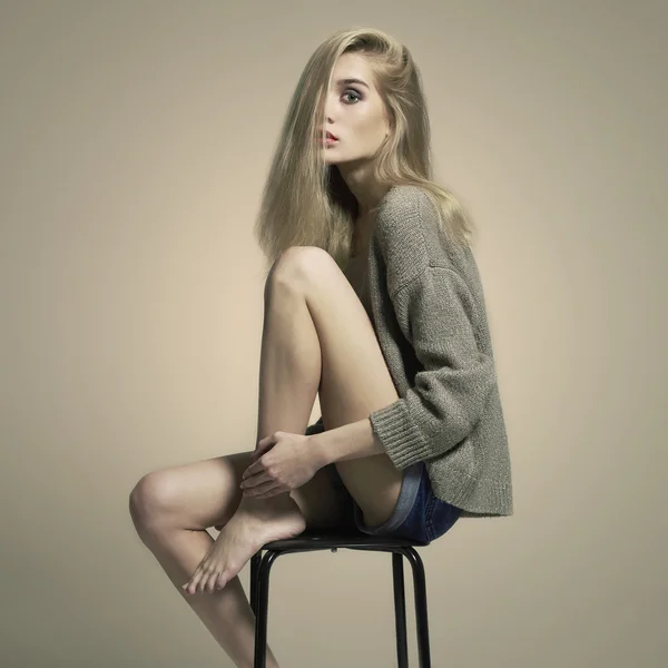Blondă care stă pe un scaun. fată frumoasă — Fotografie, imagine de stoc