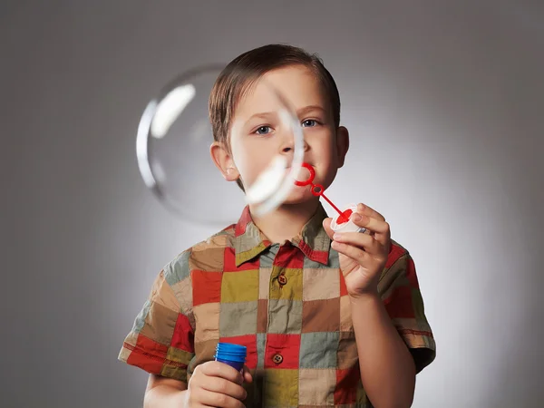 Menino soprando sabão bubbles.happy criança — Fotografia de Stock